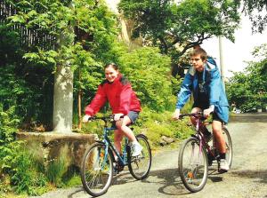 two people riding bikes down a road at Penzion Nevcehle in Urbanov