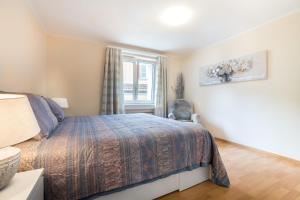 a bedroom with a bed and a window at Alpenheim Apartment in Andermatt