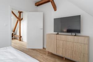 a living room with a flat screen tv on a wooden cabinet at Apartamenty SWAN in Gliwice
