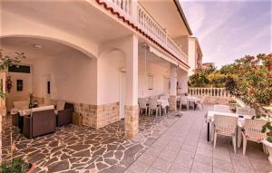 a restaurant with white tables and chairs on a patio at Eg Marjetka Bis 9 in Rab