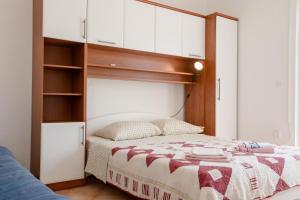 a bedroom with a bed and white cabinets at Eg Marjetka Bis 9 in Rab