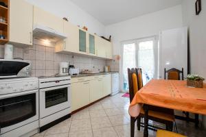 a kitchen with a table and a dining room at Eg Marjetka Bis 9 in Rab