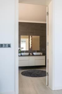 a bathroom with two sinks and a mirror at SunriseDreamHouse in Ponta Delgada +38 photos
