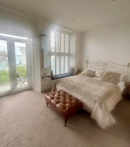 a bedroom with a large bed and a large window at Porthminster View Luxury Sea Views Balcony, Parking, Pool, Spa & Gym in St Ives +30 photos