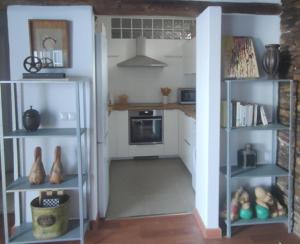 a kitchen with white cabinets and shelves in a room at Casa Vento in La Asomada