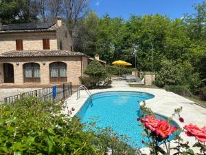 a swimming pool in front of a house at Villa Santa Maria in Montegiorgio