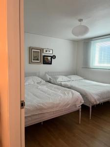 two twin beds in a bedroom with a window at 소소 하우스 in Seoul