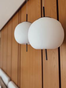 two white lights hanging on a wooden wall at villaSAMU in Amphoe Koh Samui
