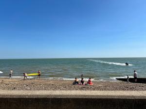 a group of people on a beach with the ocean at Rohannah A&C Ultimate Caravan Retreat in East Mersea +14 photos