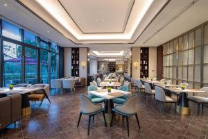 Un restaurante con mesas, sillas y ventanas. en Ascott Sunland Shanghai, en Shanghái