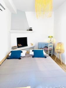 a living room with blue pillows and a tv at Villa Kastrouna, with private heated jacuzzi in Symi +34 photos