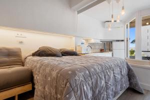 Una cama grande en una habitación con cocina. en Promar 323, en La Pineda