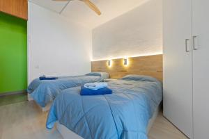 two beds in a room with blue comforters at Tirreno 304 in La Pineda