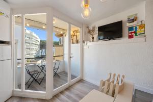 una sala de estar con una puerta corredera de cristal que conduce a un comedor en Promar 323, en La Pineda