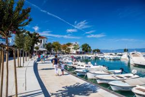 a man and a child standing next to boats in a marina at Apartment Verano in Njivice