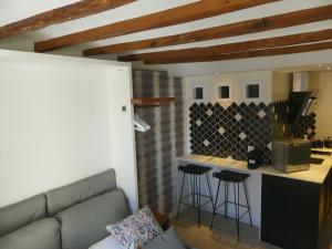 a living room with a couch and a kitchen with a counter at Casa Hermes in Villajoyosa