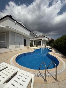 a swimming pool in front of a house at Ares Vilları in Antalya