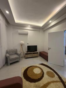 a living room with a television and a couch and a rug at Ares Vilları in Antalya