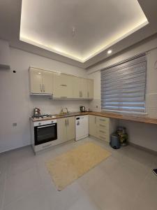 a kitchen with white cabinets and a stove top oven at Ares Vilları in Antalya