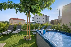 a backyard with a swimming pool and a tree at Frida in Vodice