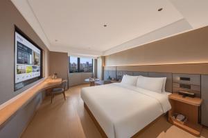 a hotel room with a large bed and a flat screen tv at JI Hotel Beijing South Railway Station North Square in Beijing +29 photos