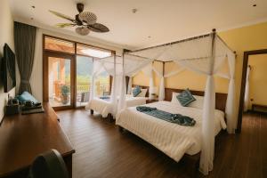 a bedroom with two beds and a ceiling fan at Tam Coc Horizon Retreat in Vũ Lâm +70 photos