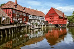 a group of red and white buildings next to a river at SJ Apartment in Aarhus