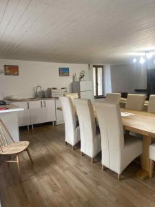 Apple Barn Cottage with 5 Bedrooms في Oradour-sur-Vayres: غرفة طعام مع طاولة وكراسي بيضاء