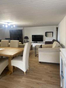 Apple Barn Cottage with 5 Bedrooms في Oradour-sur-Vayres: غرفة معيشة مع طاولة طعام وأريكة +44 صورة