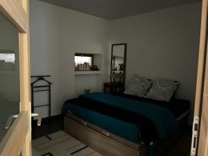 a bedroom with a green bed and a mirror at La Ruelle in Die +3 photos