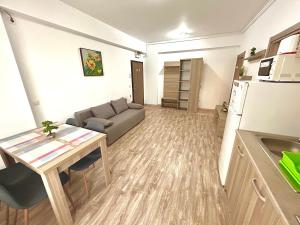 una sala de estar con un sofá y una mesa en Marcony Seaview Apartments, en Mamaia