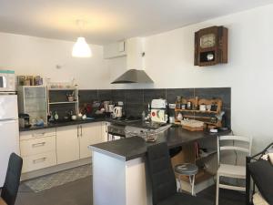 a kitchen with white cabinets and a black counter top at La Ruelle in Die
