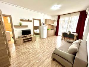Una sala de estar con un sofá y una cocina. en Marcony Seaview Apartments, en Mamaia