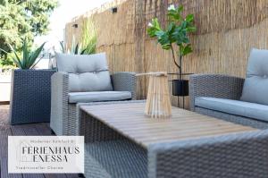 a patio with wicker chairs and a table with a plant at Ferienhaus Enessa in Lauchhammer