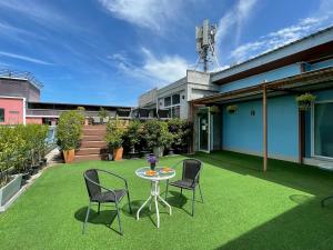 a patio with chairs and a table on a lawn at Ananya Residence Amata City Hotel in Chon Buri