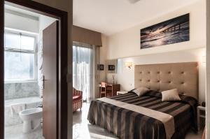 a hotel room with a bed and a bathroom at Hotel King in Marina di Pietrasanta