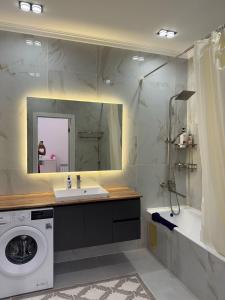 a bathroom with a sink and a washing machine at Elit in Bishkek