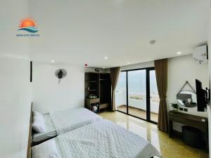 a bedroom with a bed and a view of the ocean at Sunrise Hotel Thiên Cầm in Hà Tĩnh +30 photos