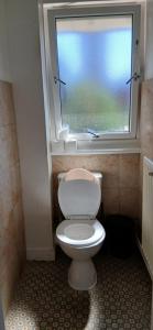 a bathroom with a white toilet and a window at Mary's Place in Plumstead