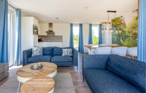 Una sala de estar con sofás azules y una mesa. en 3 Bedroom Awesome Home In Kamperland, en Kamperland