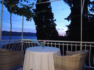 a table with a vase of flowers on a balcony at CROSurf Apartments Pelješac Kučište in Kučište