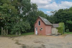 a small red brick house with a driveway at La Maisonnette - Maison atypique à la campagne 