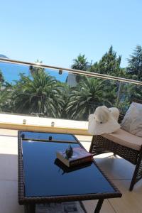 a balcony with a chair and a table with a book at Swiss Residence Montenegro in Herceg-Novi