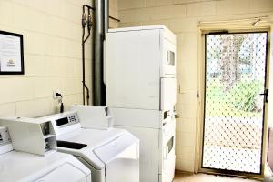 a laundry room with white appliances in front of a door at BIG4 Rutherglen Holiday Park in Rutherglen +123 photos