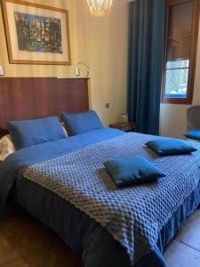 a bedroom with a large bed with blue pillows on it at A l'ombre de la cathedrale in Troyes