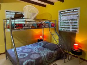 a bedroom with a bunk bed in a yellow wall at Appartement spacieux à Sainte-Rose, 70 m² avec jardin in Sainte-Rose
