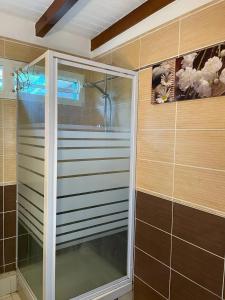 a shower with a glass door in a bathroom at Appartement spacieux à Sainte-Rose, 70 m² avec jardin in Sainte-Rose