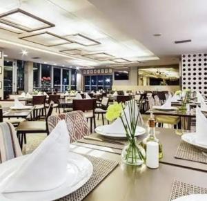 a dining room with tables and chairs and a restaurant at Suíte em Hotel de Luxo Bourbon in Belo Horizonte