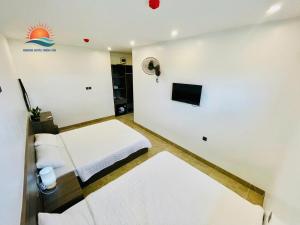 a small room with two beds and a television at Sunrise Hotel Thiên Cầm in Ha Tinh