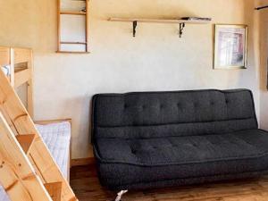 a black couch sitting in a room next to a wall at 4 person holiday home in Slöinge in Ugglarp